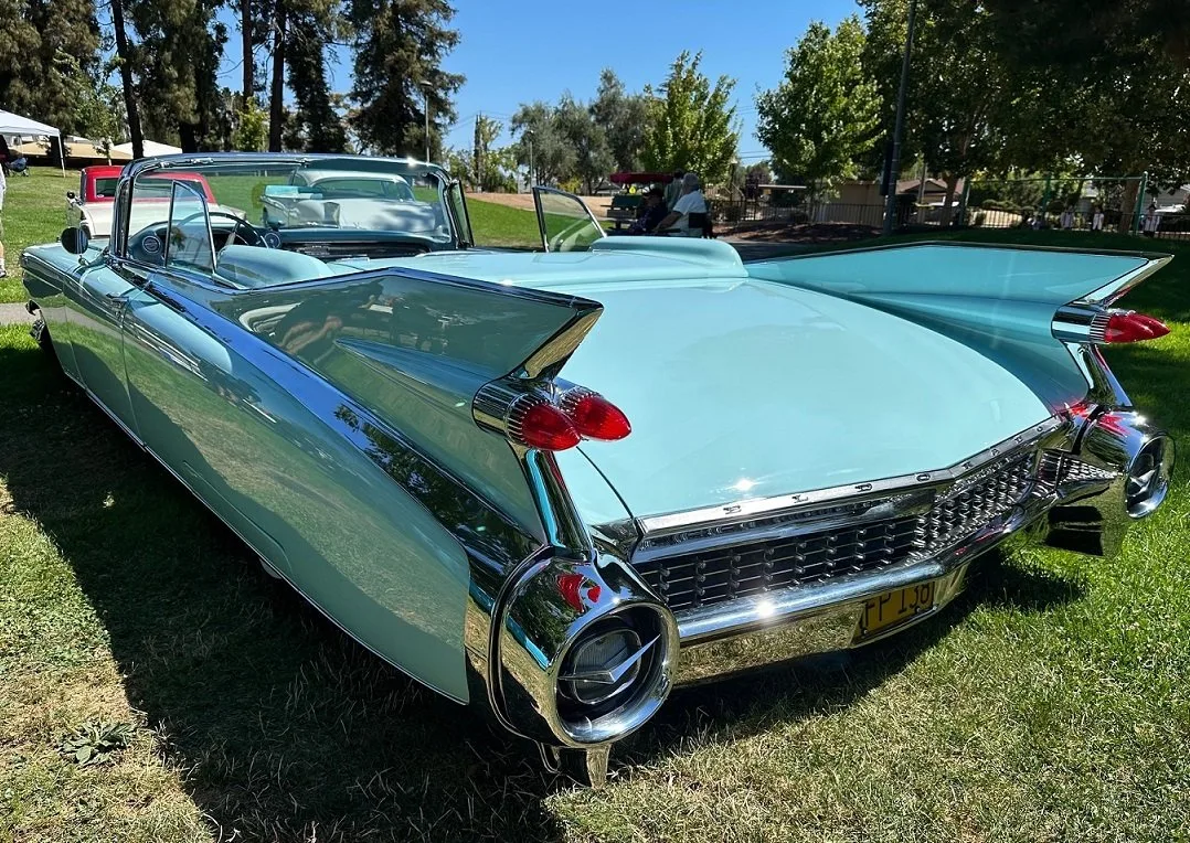 A 1959 Cadillac convertible with tall tailfins on the grass at a club show